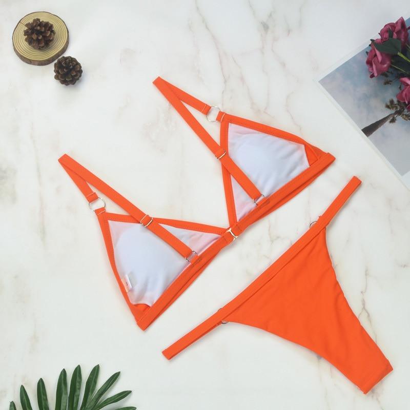 Zweiteiliges Bikini-Set in leuchtendem Orange auf Marmorhintergrund, ideal für Sommermode, Strandbekleidung, trendige Bademode.