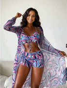 Frau in buntem, gemustertem Bikini-Set mit passendem Kimono, lächelt in die Kamera. Sommermode, Strandkleidung, trendige Bademode.