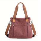 Damenhandtasche aus rosa Canvas mit braunen Trägern, Reißverschlusstaschen und abnehmbarem Schultergurt. Modisch, praktisch, vielseitig.