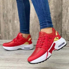 Rote Sneaker mit weißer Sohle und goldenen Akzenten, getragen von Person in blauen Jeans. Modische Sportschuhe, ideal für Freizeit und Sport.