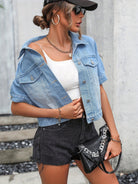 Frau in modischer Jeansjacke, weißem Top und schwarzen Shorts. Trendige Sommermode, Streetstyle, Accessoires, Sonnenbrille, urbane Eleganz.