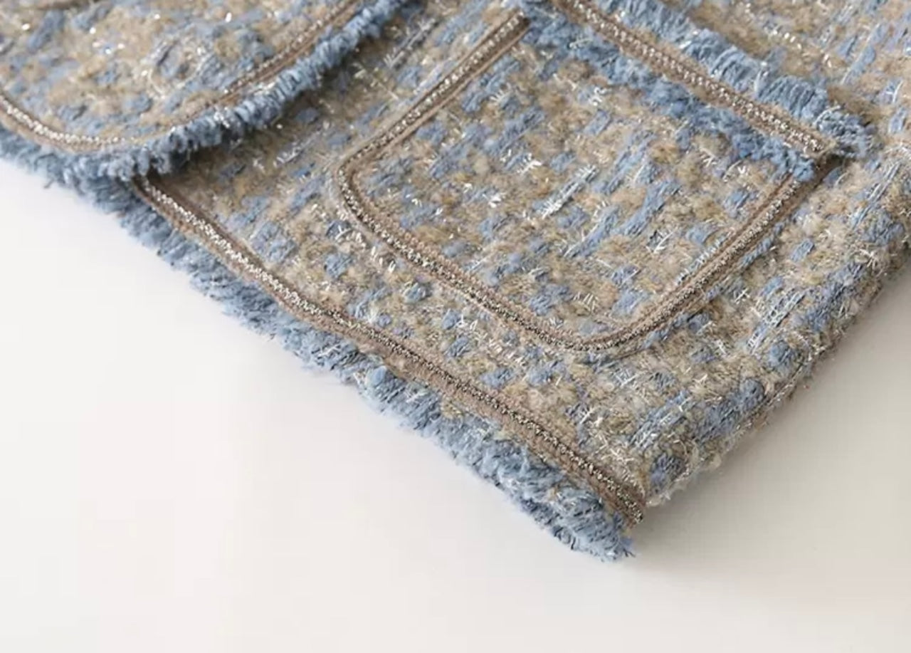 Tweedjacke Detailansicht: Hochwertiger blauer und grauer Tweedstoff mit Taschen, ideal für stilvolle Herbst- und Wintermode.