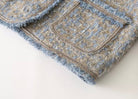 Tweedjacke Detailansicht: Hochwertiger blauer und grauer Tweedstoff mit Taschen, ideal für stilvolle Herbst- und Wintermode.
