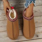 Damen-Hausschuhe aus braunem Wildleder mit weichem Futter, Perlenverzierung und rotem Strickmuster. Bequem, stilvoll, warm. Ideal für den Winter.