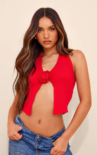 Rotes Stricktop mit Rosendetail, ärmellos, kombiniert mit blauer Jeans. Modetrend, Damenbekleidung, stilvoll, modern, elegant.