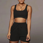 Schwarzes Sportset für Damen, bestehend aus kurzem Top und Shorts. Ideal für Fitness und Freizeit. Bequem, modisch, atmungsaktiv.