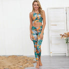 Frau in floralem Sportset, bestehend aus Leggings und Top, vor weißem Hintergrund. Perfekt für Yoga und Fitness. Trendige Sportmode.