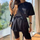 Schwarzes Sportset mit Gürtel, bestehend aus Oversize-T-Shirt und Radlerhose. Perfekt für Fitness, Freizeit und trendige Streetwear-Looks.