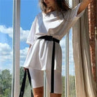 Weißes Sportset mit Gürtel für Damen, bestehend aus lockerem T-Shirt und Radlerhose. Perfekt für Fitness, Yoga und Freizeit. Bequem und stilvoll.