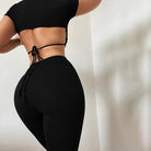 Schwarzes Sportset für Damen, bestehend aus kurzem Oberteil und Leggings. Perfekt für Fitness, Yoga und Freizeit. Bequem und stilvoll.