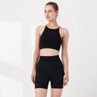 Schwarzes Sportset für Damen, bestehend aus kurzem Top und Shorts. Ideal für Fitness, Yoga und Training. Atmungsaktiv und bequem.