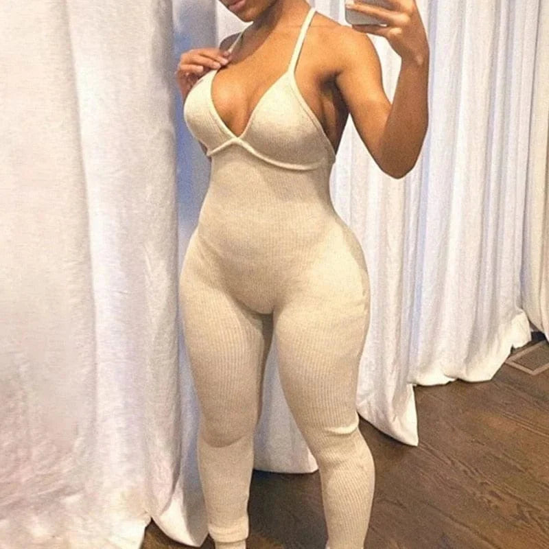 Beiger einteiliger Sportanzug mit tiefem Ausschnitt, figurbetont, ideal für Fitness und Freizeit. Trendige Damenmode, bequem und stilvoll.