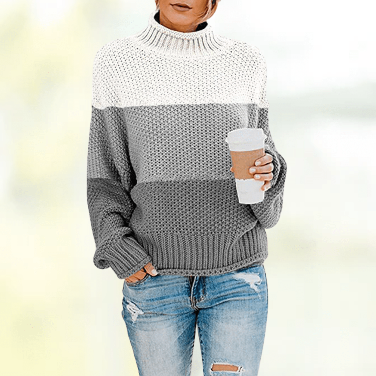 Eleganter gestreifter Pullover in Grau und Weiß, ideal für Herbstmode. Perfekt kombiniert mit zerrissenen Jeans. Trendige Damenbekleidung.