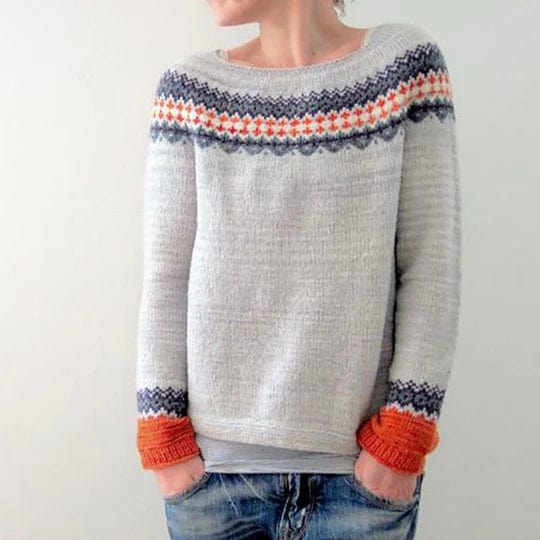 Grauer Boho-Pullover mit buntem Strickmuster, ideal für Herbstmode. Bequem und stilvoll, perfekt kombinierbar mit Jeans für einen lässigen Look.