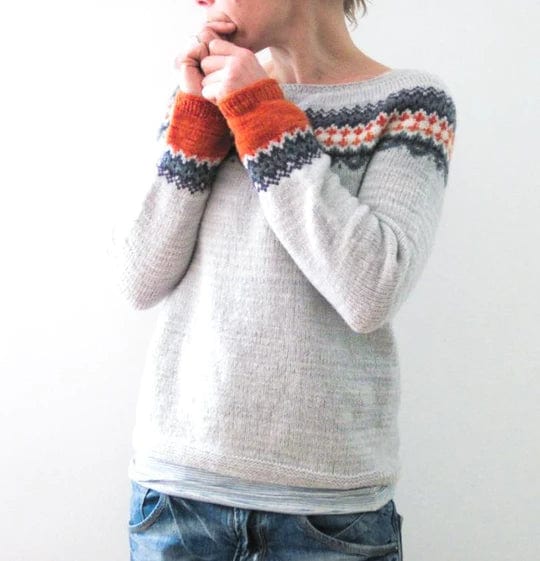 Grauer Boho-Pullover mit buntem Strickmuster, ideal für Herbstmode. Bequem und stilvoll, perfekt für lässige Outfits und kühle Tage.