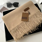 Beige Kaschmirschal mit Fransen, stilvoll und weich, ideal für Herbst und Winter. Perfektes Accessoire für Damenmode. Luxuriös und elegant.