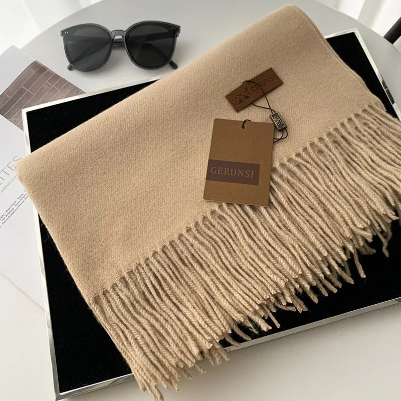 Beige Kaschmirschal mit Fransen, stilvoll und weich, ideal für Herbst und Winter. Perfektes Accessoire für Damenmode. Luxuriös und elegant.