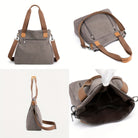 Stylische graue Canvas-Umhängetasche mit braunen Ledergriffen, ideal für Damen. Praktisch, geräumig, modisch, perfekt für Alltag und Reisen.