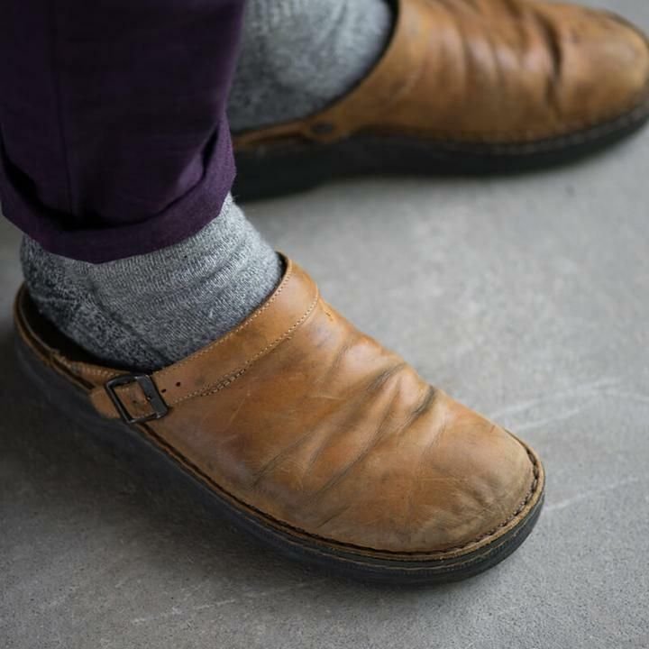 Brauner Lederschuh mit Schnalle, getragen mit grauen Socken. Bequeme, stilvolle Herrenschuhe, ideal für Freizeit und Alltag. Vintage-Look.