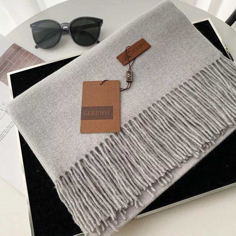 Grauer Kaschmirschal mit Fransen von GERUNSI, elegant und weich, ideal für Herbst und Winter. Perfektes Accessoire für stilvolle Outfits.