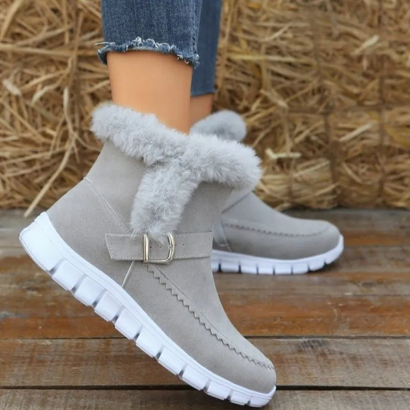 Damen-Winterstiefel aus grauem Wildleder mit Kunstfellfutter, rutschfester Sohle und Schnallenverschluss. Perfekt für kalte Tage und modische Outfits.