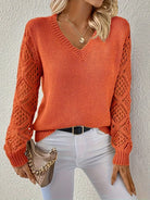 Damenpullover in leuchtendem Orange mit V-Ausschnitt und gehäkelten Ärmeln, kombiniert mit weißer Hose. Modetrend, Herbstmode, Strickpullover.
