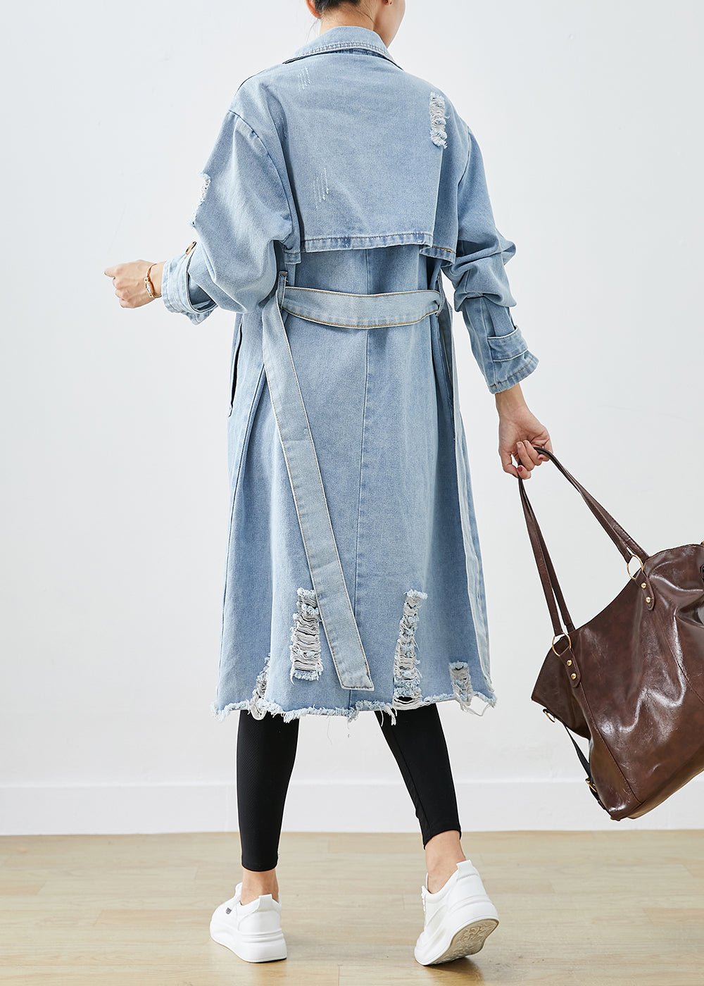 Hellblauer, zerrissener Denim-Mantel mit Revers und doppelter Knopfleiste, ideal für den Herbst. Modischer Damenmantel, lässiger Streetwear-Stil.