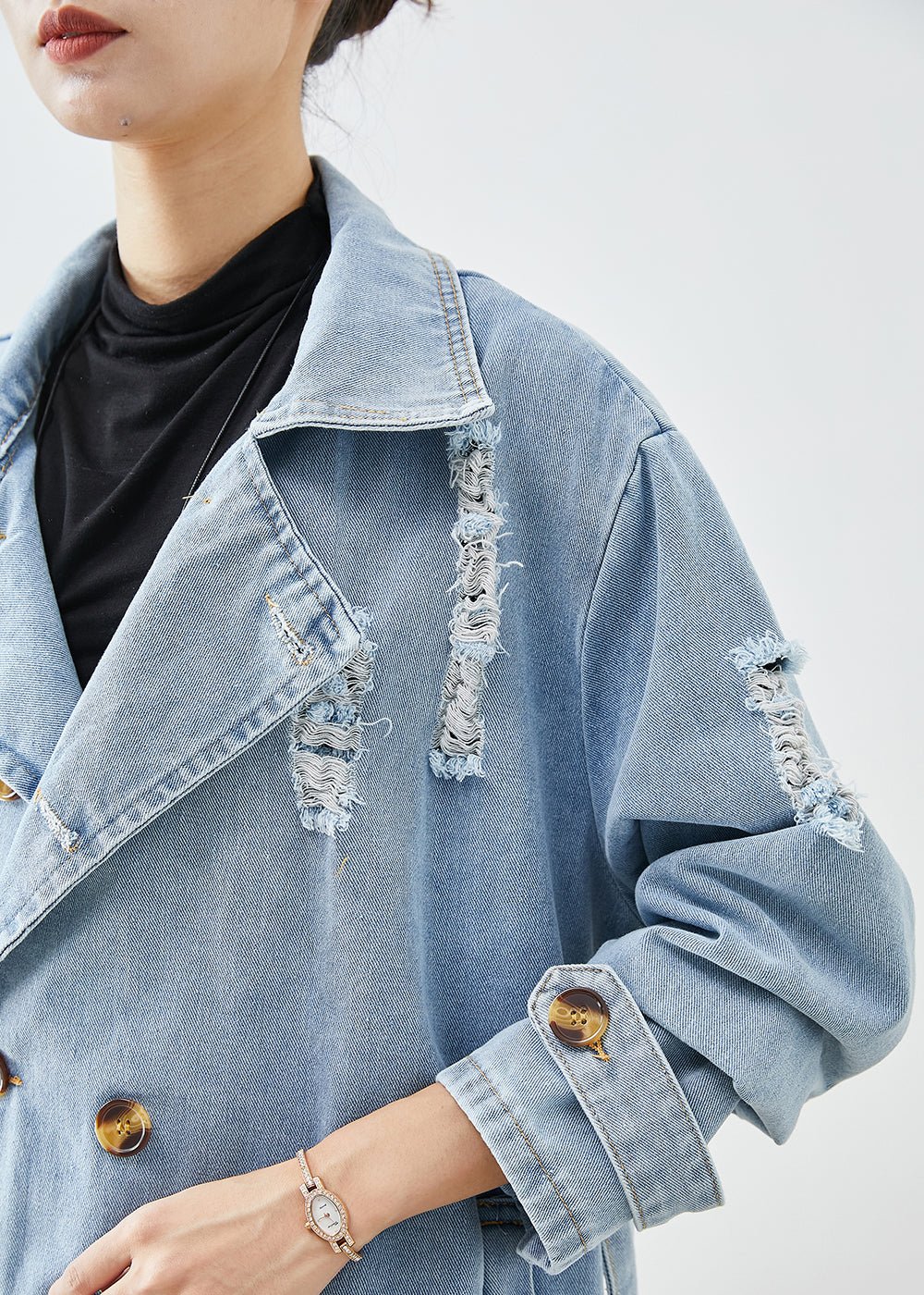Hellblauer Denim-Mantel mit Revers, doppelreihig, zerrissenem Design. Perfekt für den Herbst. Modischer Damenmantel, lässiger Streetstyle.