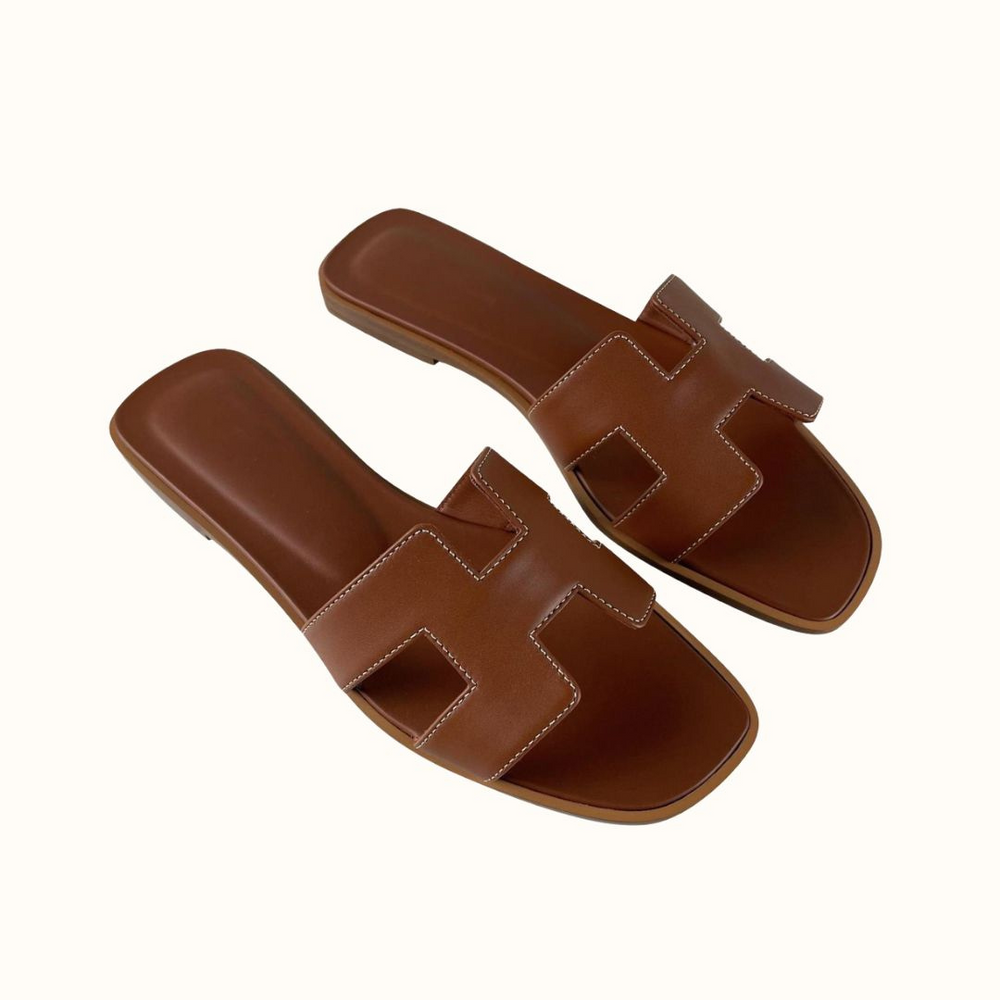 Braune Ledersandalen mit quadratischer Zehenpartie und markantem Riemen-Design. Perfekt für Sommermode und lässige Outfits.