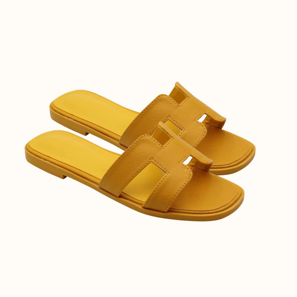Gelbe Damen-Sandalen aus Leder mit flachem Absatz und offenem Zehenbereich. Perfekt für Sommermode und bequemen Alltagsstil.