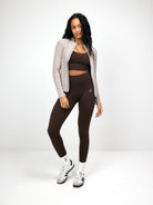 Damen-Sportoutfit: Taupefarbene Zip-Bluse und braune Leggings. Perfekt für Fitness, Yoga und Freizeit. Bequeme, stilvolle Sportbekleidung.