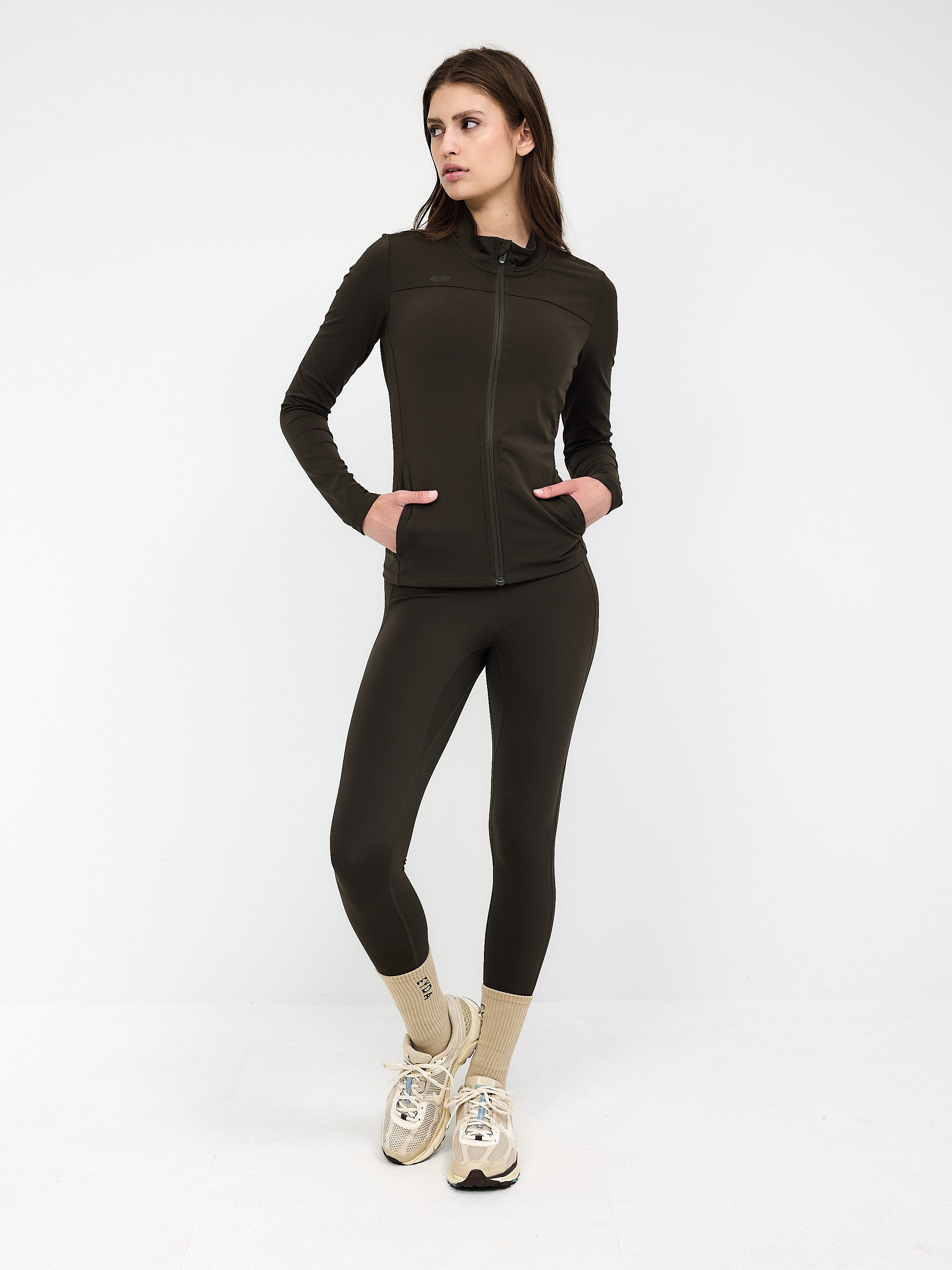 Damen-Sportanzug in Dunkeloliv, bestehend aus Reißverschlussjacke und Leggings. Ideal für Fitness, Yoga und Freizeit. Bequem und stilvoll.