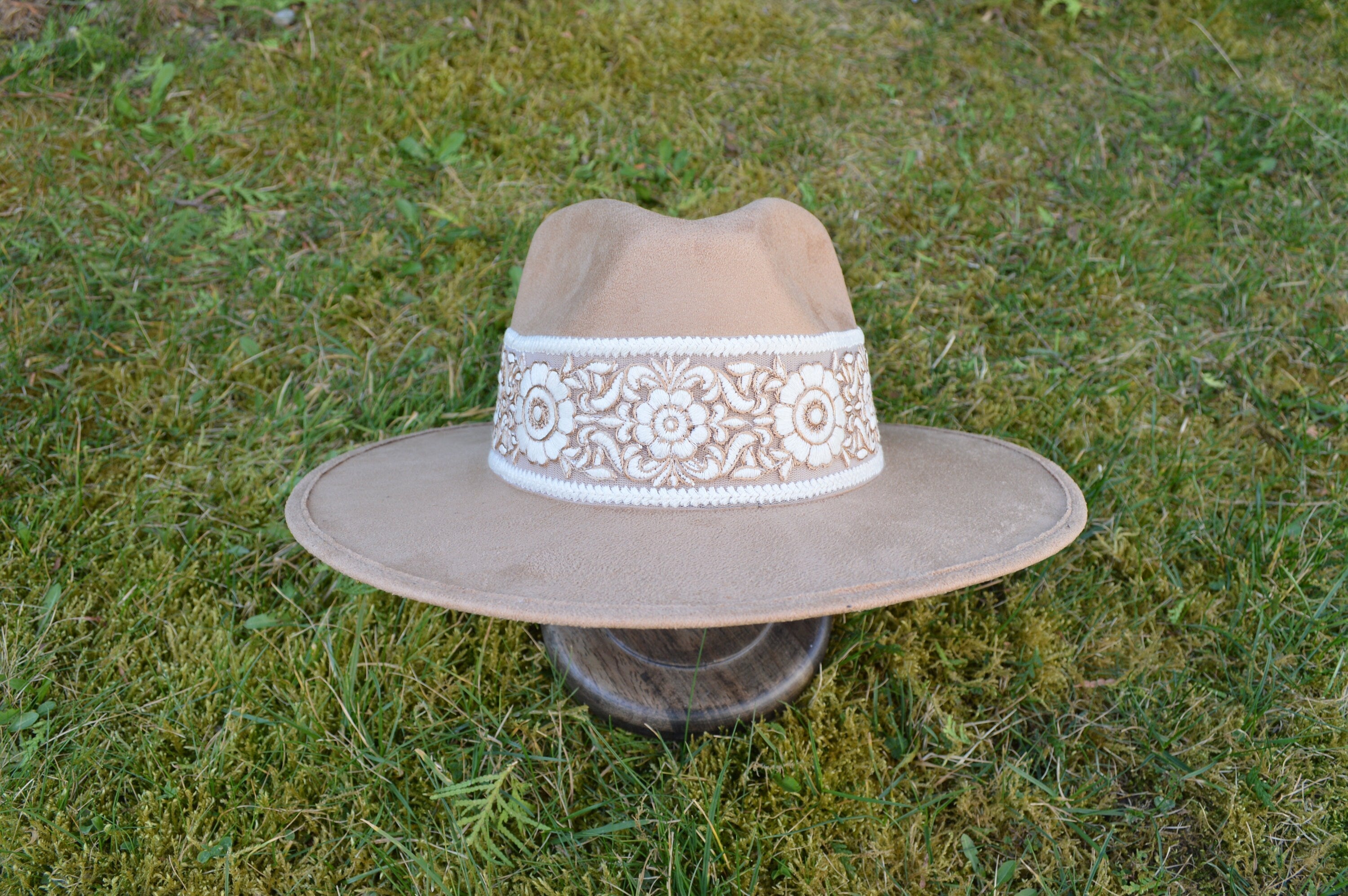 Breiter, beige Cowboyhut mit aufwendiger weißer Stickerei auf der Krempe, ideal für Westernmode und Outdoor-Abenteuer. Hochwertige Handwerkskunst.