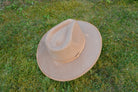 Brauner Filzhut auf grünem Gras, klassisches Design, ideal für Outdoor-Aktivitäten. Perfekt für Herrenmode, Vintage-Look, stilvoll und robust.