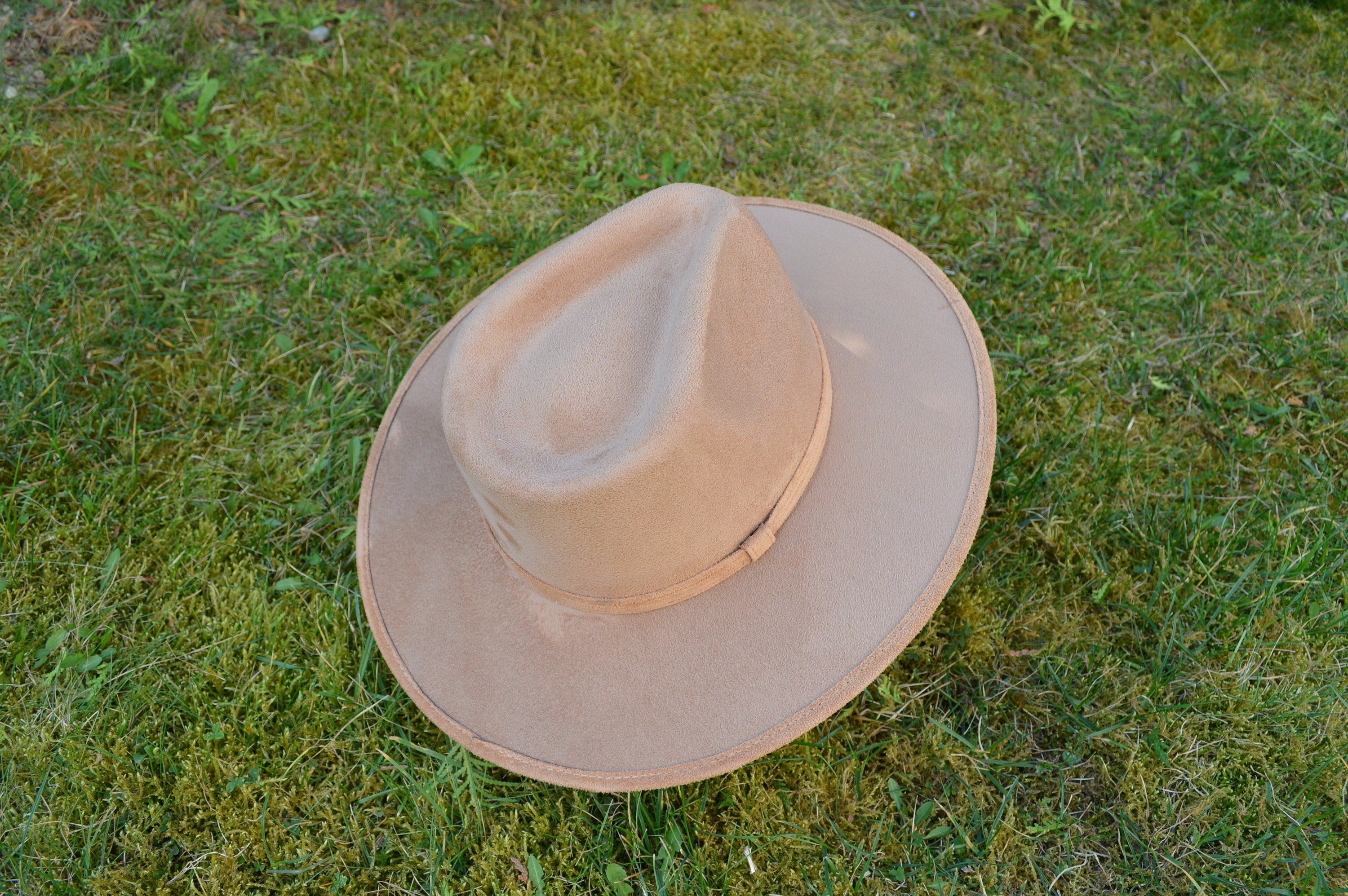 Brauner Filzhut auf grünem Gras, klassisches Design, ideal für Outdoor-Aktivitäten. Perfekt für Herrenmode, Vintage-Look, stilvoll und robust.