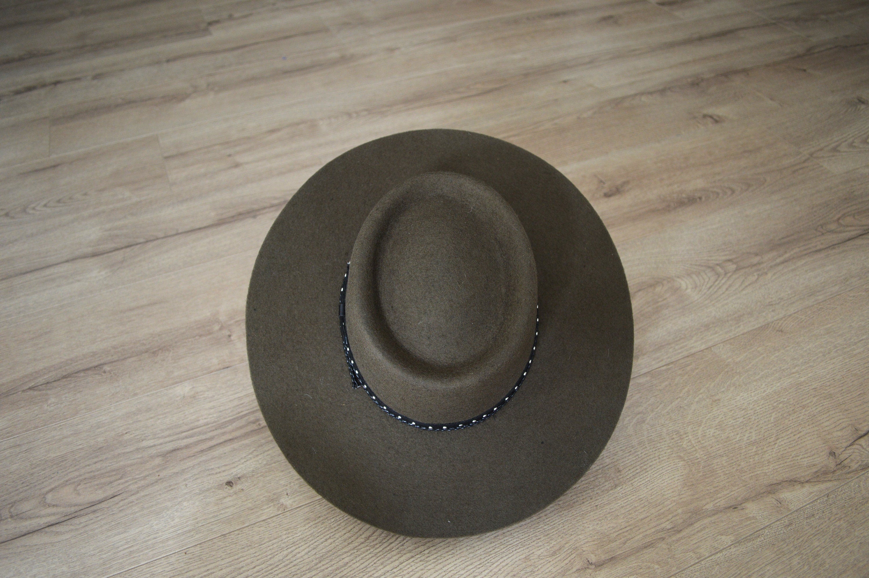 Brauner Filzhut auf Holzboden, stilvoll und klassisch. Perfekt für Herbstmode, Vintage-Look und elegante Accessoires.