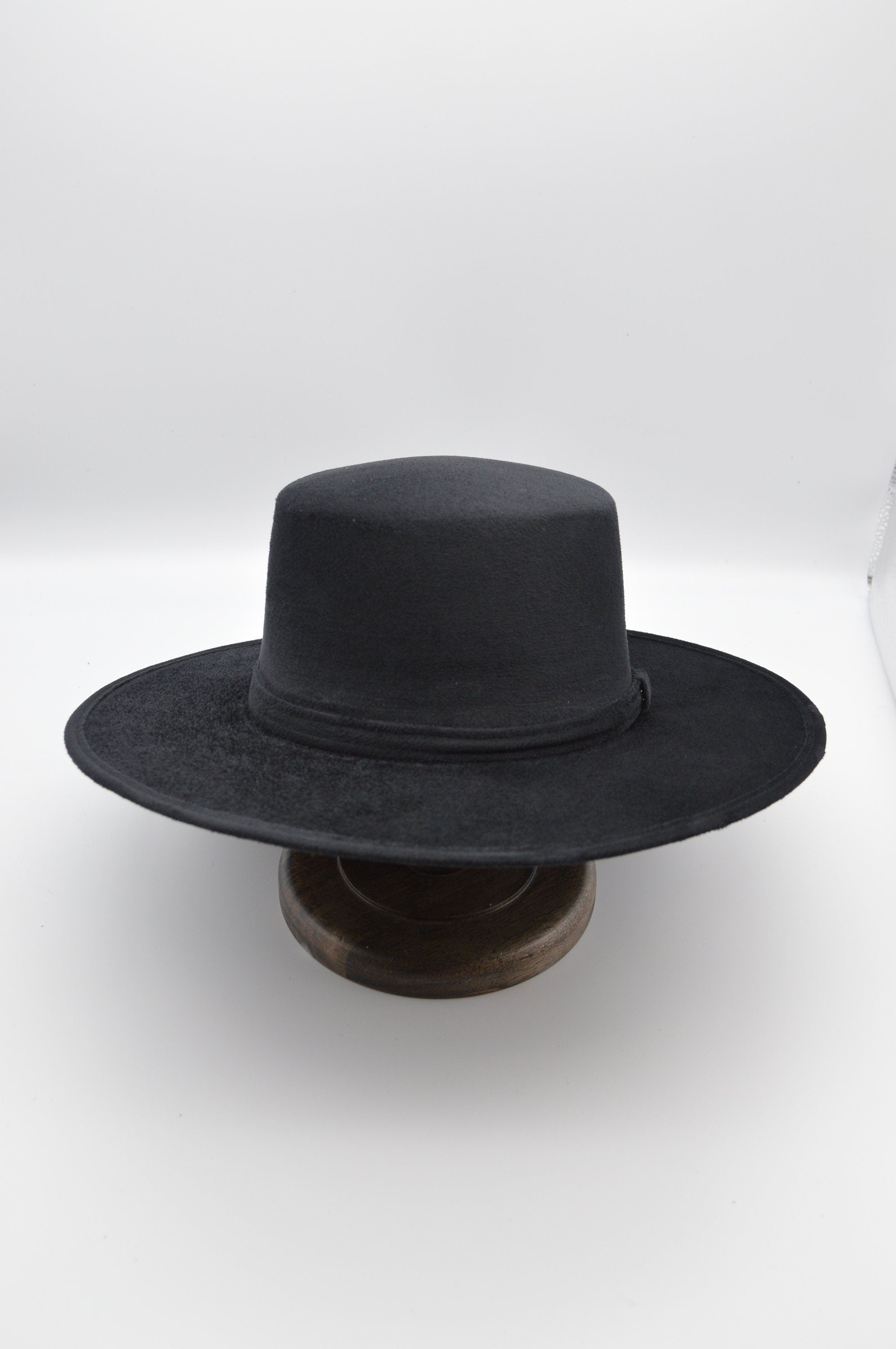 Schwarzer Filzhut mit breiter Krempe auf Holzständer, klassisches Design, ideal für stilvolle Outfits, zeitloser Modeaccessoire.