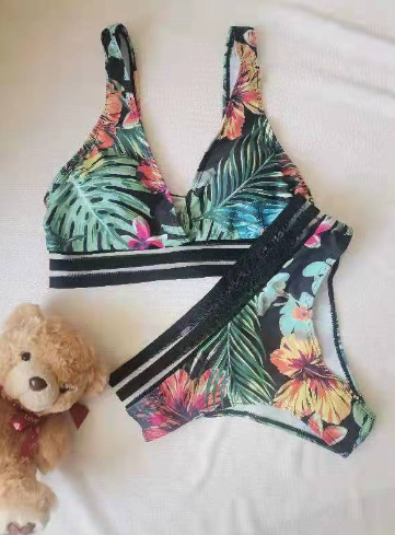 Bunter Bikini mit tropischem Blumenmuster, bestehend aus Triangel-Oberteil und Slip. Perfekt für Strandurlaub und Sommermode.