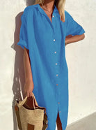 Frau in blauem Leinenkleid mit Knopfleiste, hält eine Strohtasche, Sommermode.