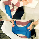 Frau mit blauem Lendenkissen auf Bürostuhl, ergonomische Unterstützung, Rückenschmerzen lindern.