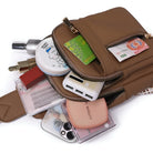 Braune Lederhandtasche mit Kosmetik, Geldscheinen und Smartphone-Zubehör, ideal für Damen.