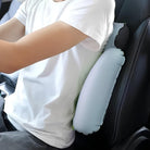Mann mit weißem T-Shirt nutzt aufblasbares Rückenkissen im Auto für ergonomischen Komfort.