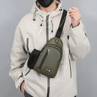 Person mit olivgrüner Umhängetasche, beige Jacke, Kopfhörer, urbaner Stil.