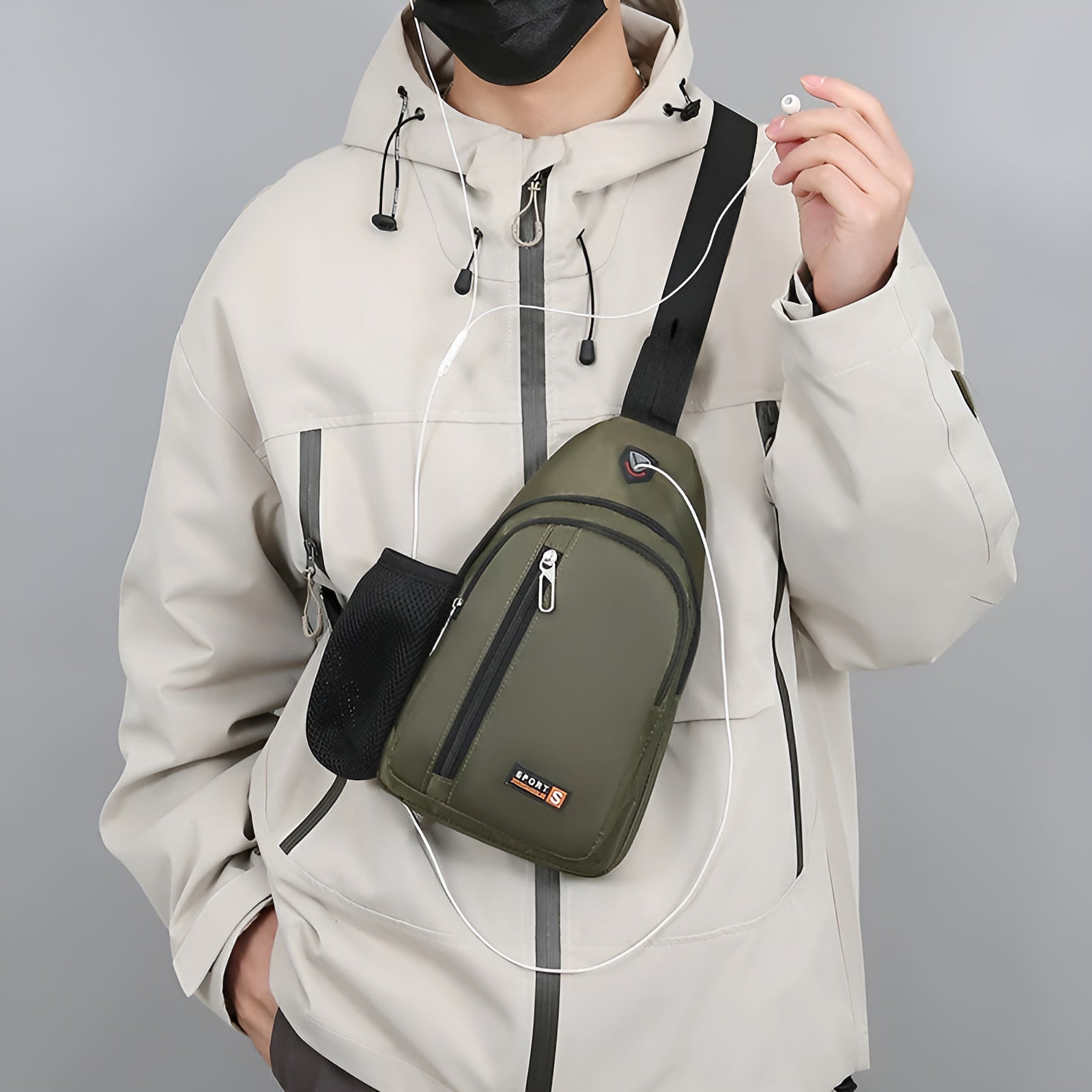 Person mit olivgrüner Umhängetasche, beige Jacke, Kopfhörer, urbaner Stil.