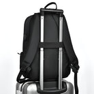 Schwarzer Rucksack auf silbernem Koffer, Reisegepäck, strapazierfähiges Material, modernes Design.