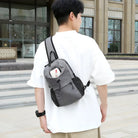 Mann mit grauem Rucksack, lässige Mode, Outdoor, Freizeitkleidung, urbaner Stil.