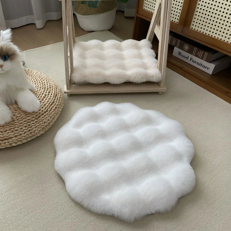 Weiße, flauschige Katzenmatte aus Kunstfell, rund, auf Teppichboden, dekorativ und gemütlich.
