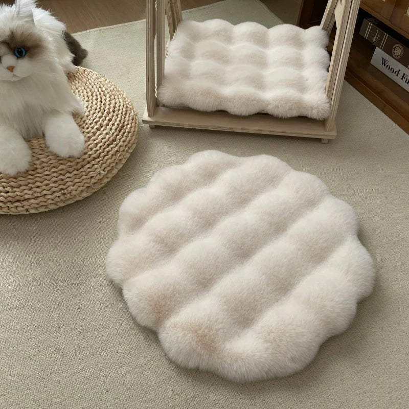 Runder, flauschiger Teppich in Cremefarbe auf beigem Boden, dekorativer Katzenkorb daneben.