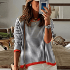 Gestreifter Pullover mit orangefarbenem Rand, modisch und bequem, ideal für den Herbst. Perfekt kombinierbar mit lässigen Outfits.