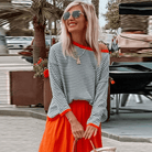 Blau-gestreifter Pullover mit orangefarbenem Rand, modisch und lässig, ideal für den Herbst. Perfekt kombiniert mit einem roten Rock.